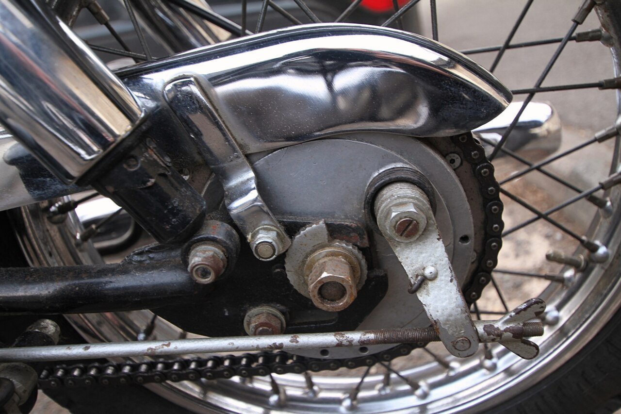 Motorcycle sprocket gearing in action — drive chain wrapped around a rear sprocket