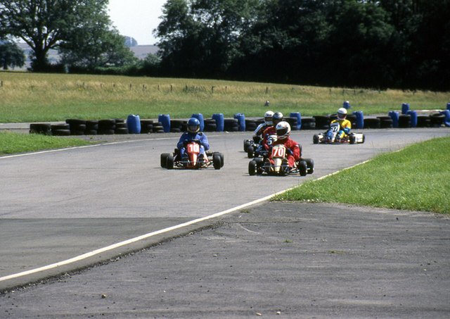 Racing go-karts through a corner — corner-exit drive rewards shorter gearing