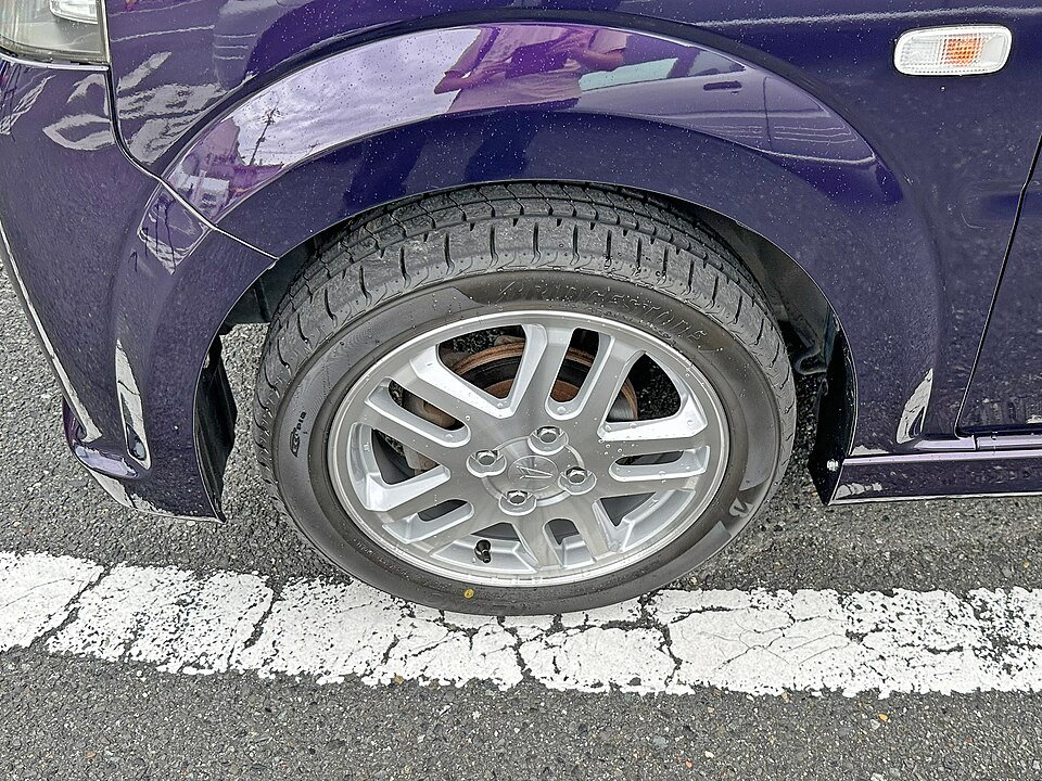 Close-up of a car tire and wheel — taller tires are the most common reason a speedometer reads wrong
