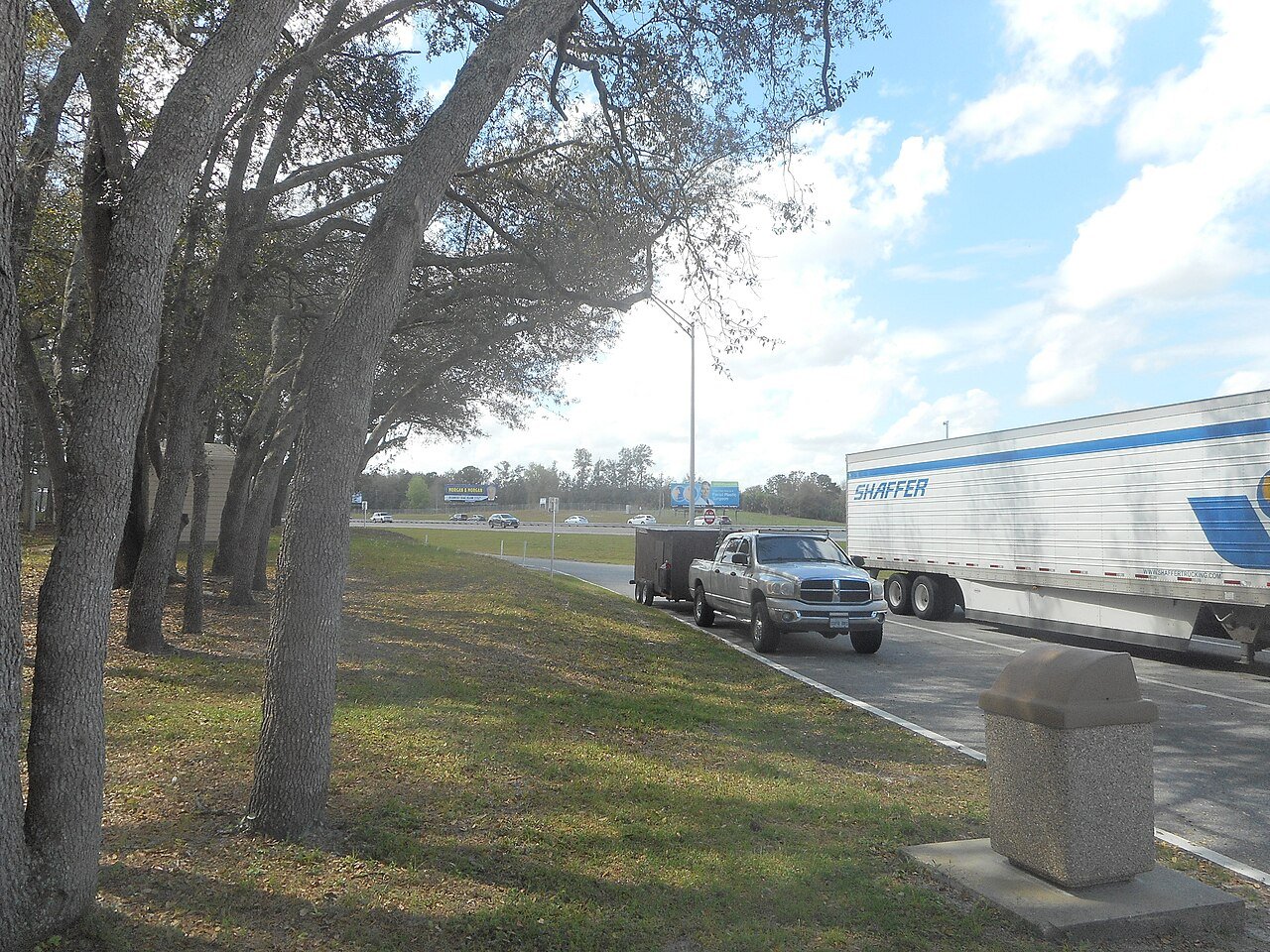 Dodge Ram pickup towing a cargo trailer at a highway rest area — picking the best gear ratio for towing keeps this kind of load relaxed on grades